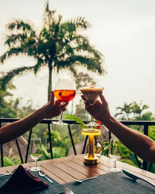two people holding up wine glasses at a table at Oxygen Jungle Villas & Spa in Uvita