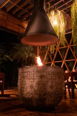 a pendant light hanging over a pot with a fire in it at Oxygen Jungle Villas & Spa in Uvita