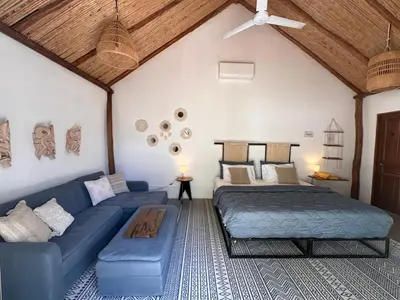 a bedroom with a blue couch and a bed at Curiol Boutique Hotel & Lounge in Potrero