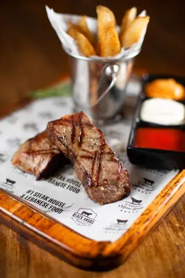 a piece of steak and french fries on a table at La Fortuna Downtown Boutique Hotel in Fortuna