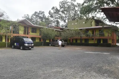 a person standing in a parking lot in front of a building at Hotel Santa Ana Liberia Airport in Liberia