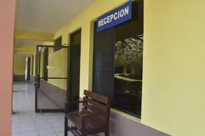 a wooden bench sitting outside of a hospital building at Hotel Santa Ana Liberia Airport in Liberia