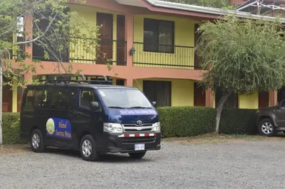 a blue van parked in front of a building at Hotel Santa Ana Liberia Airport in Liberia