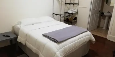 a white bed with a towel on it in a room at Casa Mayela Guest House in San José