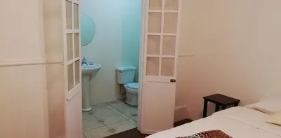 a small bathroom with a toilet and a sink at Casa Mayela Guest House in San José