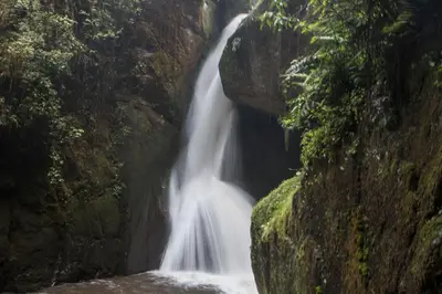 a waterfall in the middle of a rocky canyon at Hotel de Montaña Suria in San Gerardo de Dota
