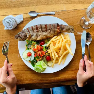 a plate of food with a fish and french fries at Hotel de Montaña Suria in San Gerardo de Dota