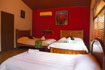 a room with two beds and a red wall at Hotel Boutique Meraki in Caldera