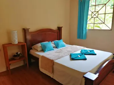 a bedroom with a bed with blue towels on it at Garden of Heliconias Lodge in Drake