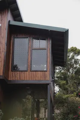 a house with windows on the side of it at Lauraceas Lodge in San Gerardo de Dota