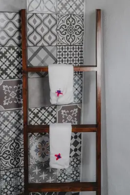 a shelf with two towels on a wall with tiles at Lauraceas Lodge in San Gerardo de Dota