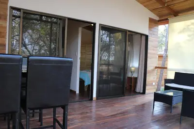 a dining room with glass doors and a table and chairs at CASA NATURaL in Brasilito
