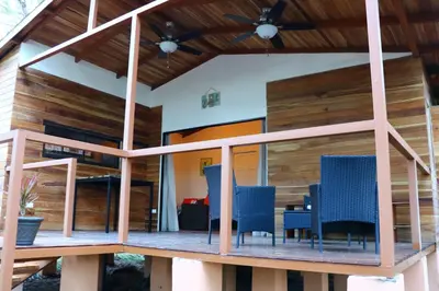 a deck with blue chairs on a house at CASA NATURaL in Brasilito