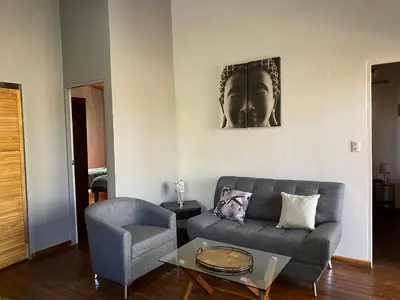 a living room with a couch and a chair at CASA NATURaL in Brasilito