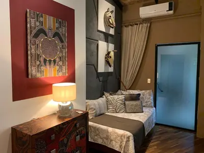 a bedroom with a bed and a table with a lamp at Villa Don Vito in Tamarindo