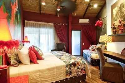 a bedroom with a bed and a chair in it at Villa Don Vito in Tamarindo