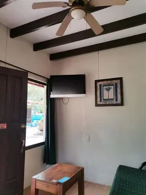 a living room with a ceiling fan and a table at Diuwak in Dominical