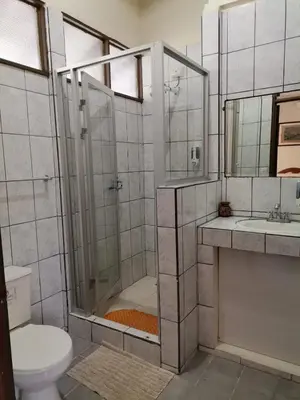 a bathroom with a shower and a toilet and a sink at Diuwak in Dominical
