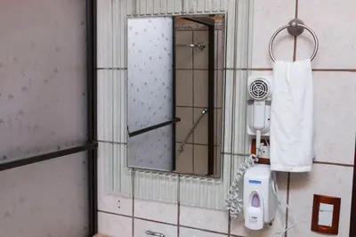 a bathroom with a mirror and a hair dryer at Diuwak in Dominical