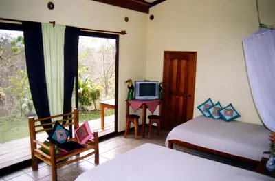 a bedroom with a bed and a tv and a desk at Fidelito Ranch & Lodge in Tambor