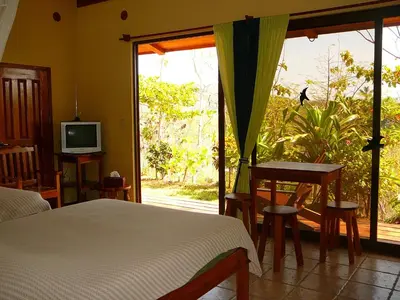 a bedroom with a bed and a sliding glass door at Fidelito Ranch & Lodge in Tambor