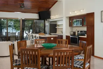 a kitchen and dining room with a wooden table and chairs at Casa Woodbine Private House on Tamarindo Beach in Tamarindo