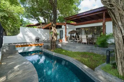 a swimming pool in the backyard of a house at Casa Woodbine Private House on Tamarindo Beach in Tamarindo
