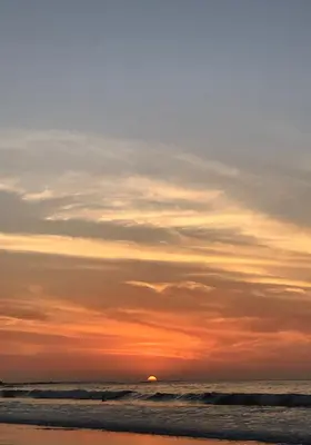 a sunset on a beach with the ocean at Casa Woodbine Private House on Tamarindo Beach in Tamarindo