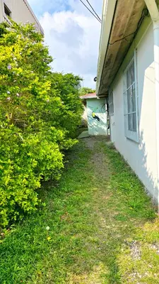 a yard next to a white building with bushes at HOUSE CATTLEYA monteverde in Monteverde Costa Rica