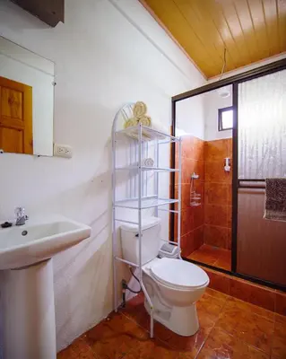 a bathroom with a toilet and a sink and a shower at HOUSE CATTLEYA monteverde in Monteverde Costa Rica