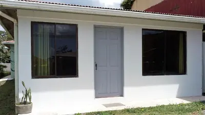 a white house with a door and windows at HOUSE CATTLEYA monteverde in Monteverde Costa Rica