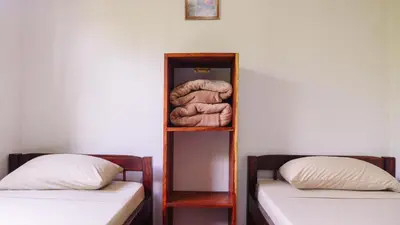 a book shelf with two beds in a room at HOUSE CATTLEYA monteverde in Monteverde Costa Rica