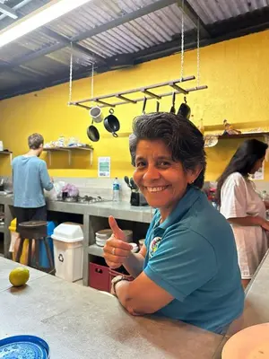 a woman sitting at a counter in a kitchen at Costa Rica Backpackers in San José