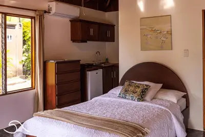 a bedroom with a bed and a kitchen at Tranquilidad Resort in Parrita