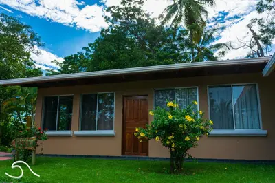 a small house with a tree in the yard at Tranquilidad Resort in Parrita
