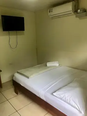 a bedroom with two beds and a tv on the wall at Le Petit Hotel in Fortuna