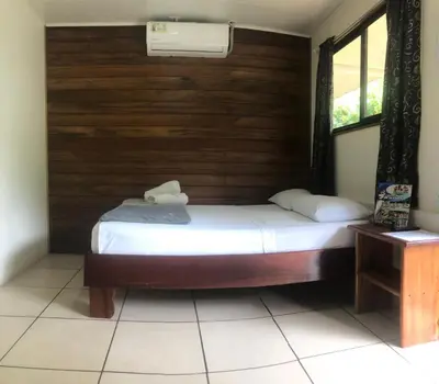 a bedroom with a bed with a wooden wall at Le Petit Hotel in Fortuna