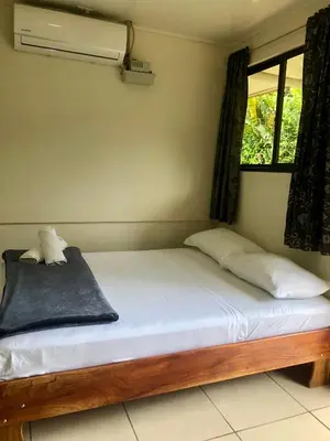 a bedroom with a bed with white sheets and a window at Le Petit Hotel in Fortuna