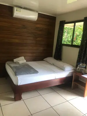 a bedroom with a bed with a wooden wall at Le Petit Hotel in Fortuna