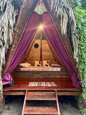 a bed in a tent with a light in it at Centro Ananda, Cabina, Bambuszelt in Guápiles