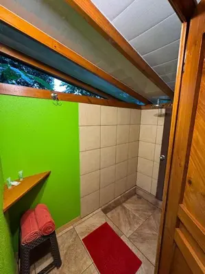 a green and white bathroom with a sink and a shower at Centro Ananda, Cabina, Bambuszelt in Guápiles