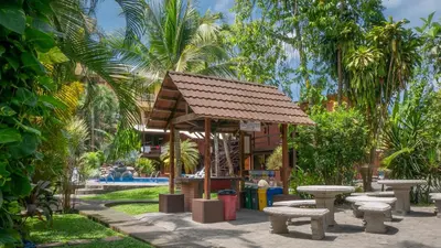 a group of benches and a pavilion in a park at Hotel Los Ranchos in Jacó