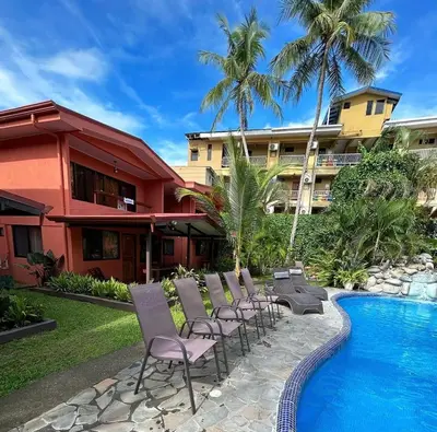 a group of chairs sitting next to a swimming pool at Hotel Los Ranchos in Jacó