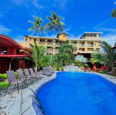 a resort with a pool and chairs and a building at Hotel Los Ranchos in Jacó