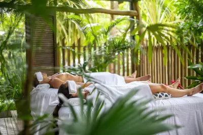 a man laying on a bed in a garden at Pumilio Mountain & Ocean Hotel in Jacó