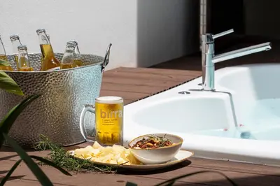 a table with a bowl of food and a glass of beer at Pumilio Mountain & Ocean Hotel in Jacó
