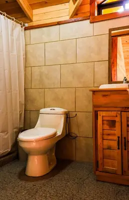 a bathroom with a toilet and a sink at Clusia Lodge in El Copey