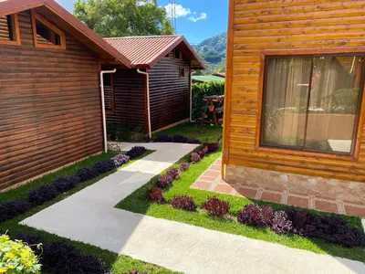 a house with a garden next to a building at Clusia Lodge in El Copey