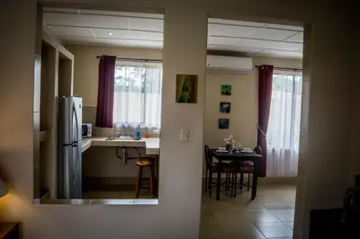 a kitchen and dining room with a table and a refrigerator at Villa Creole in Jacó