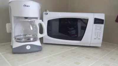 a coffee maker and a microwave on a kitchen counter at Villa Creole in Jacó